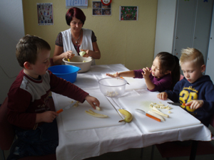 Köchin und Kinder beim Essen zubereiten