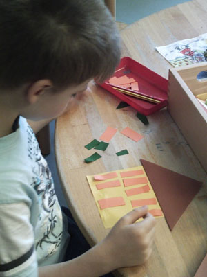Junge bastelt Papierhaus