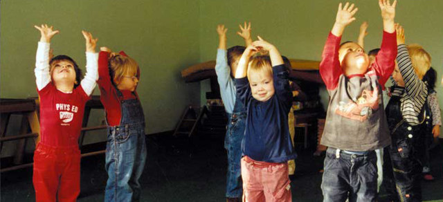 Kindergruppe streckt Arme in die Höhe