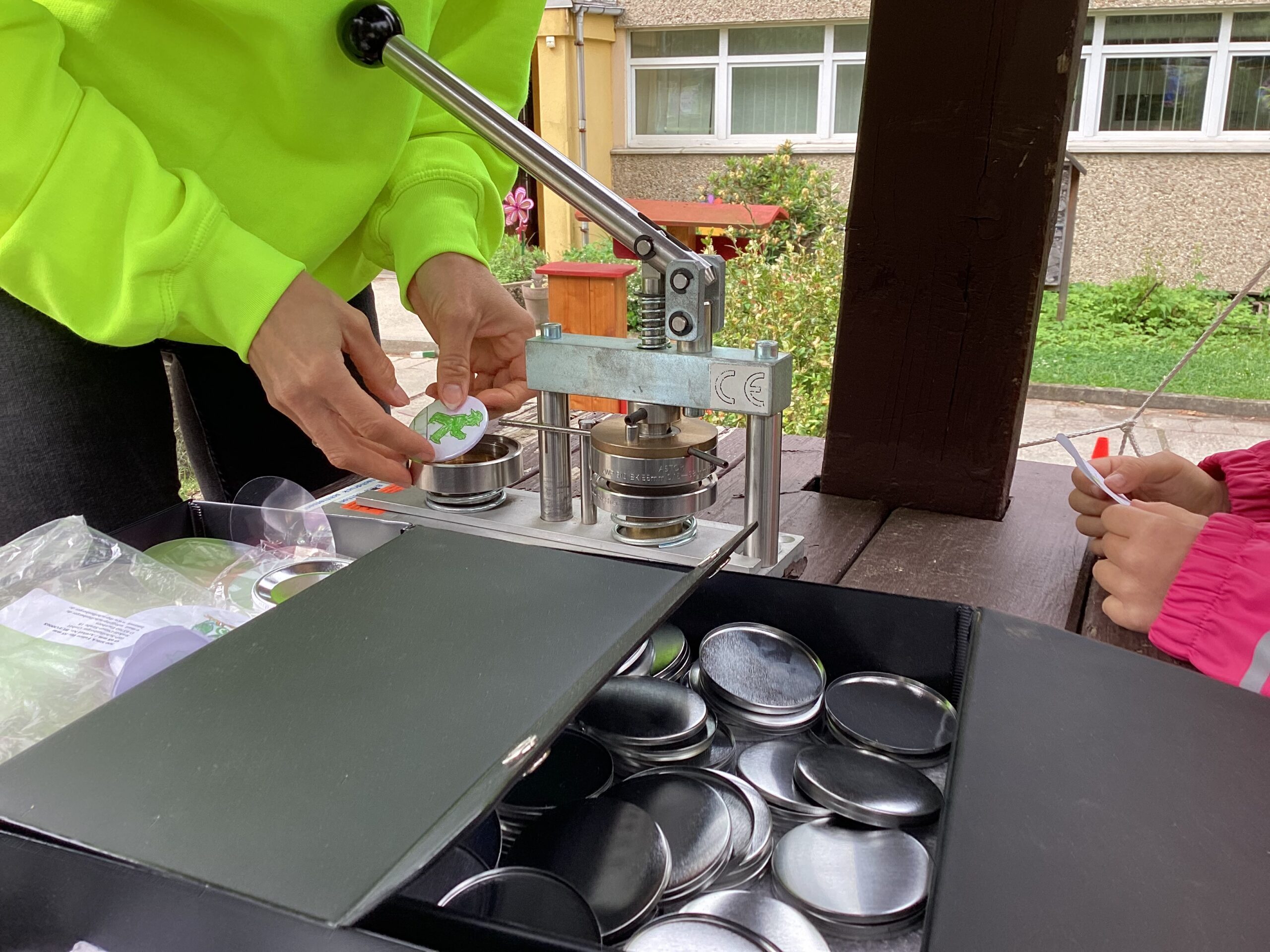 Frau bastelt mit Kind Anstecker mit der Buttonmaschine