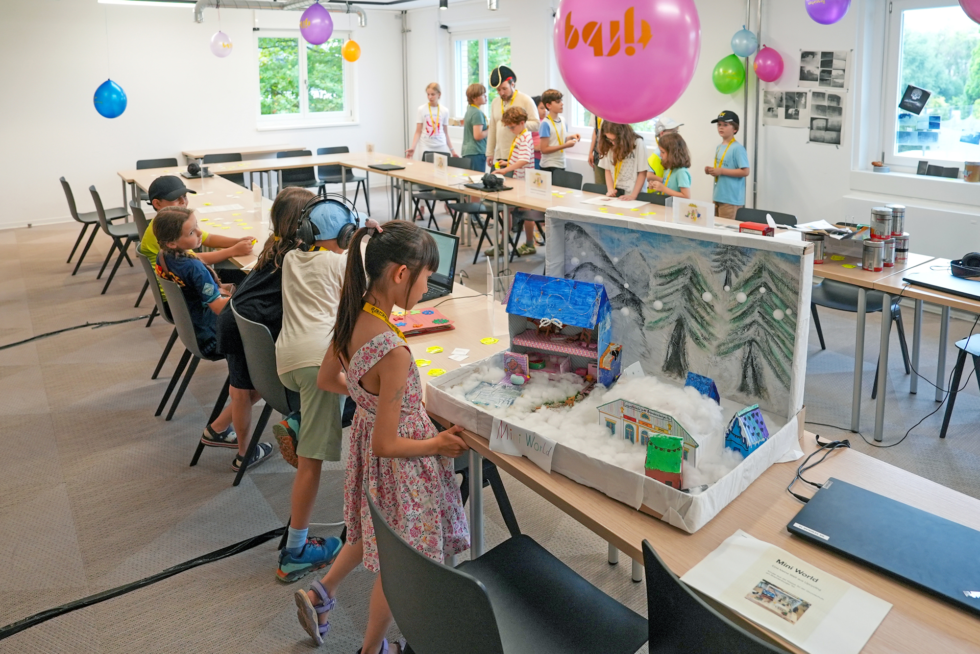Ein Mädchen und andere Kinder sind im Raum der Exponate. Sie sieht sich die Miniwelt an.